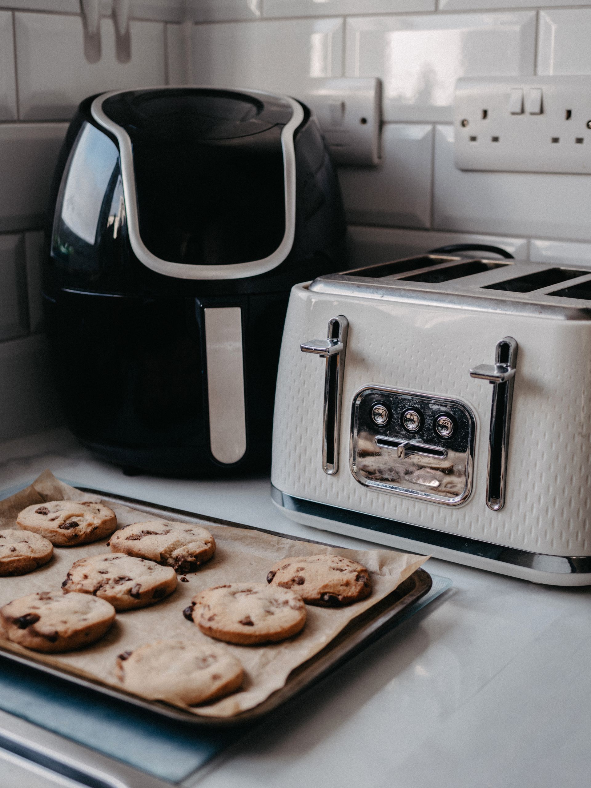 An air fryer on a kitchen counter with a basket of crispy fries
