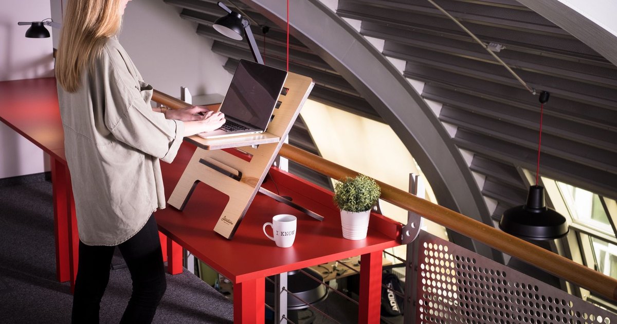 A standing desk with dual monitors and a keyboard at seated and standing height
